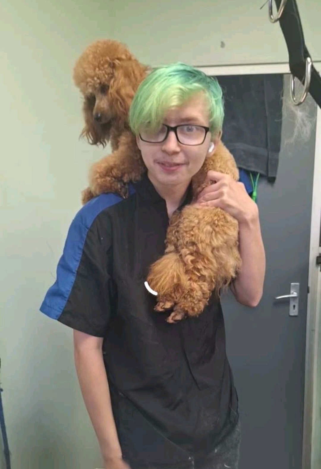 Charlie, the groomer at Cherry Spa, holding a poodle